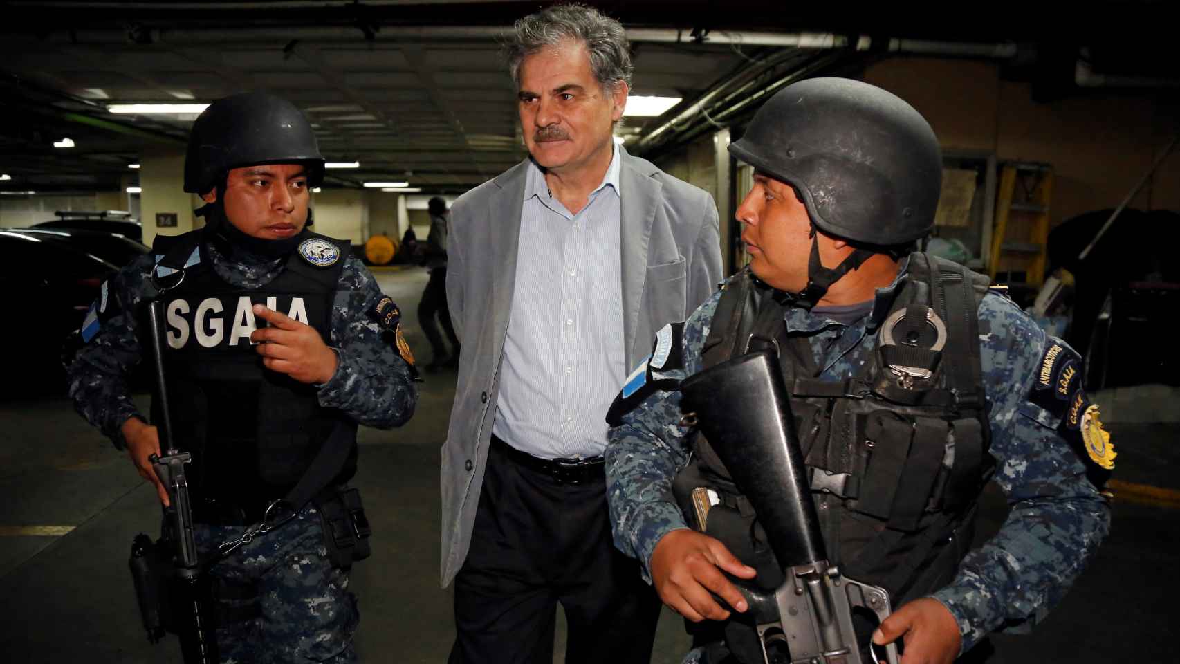 El presidente de Oxfam, Juan Alberto Fuentes, escoltado por la Policía tras su detención.