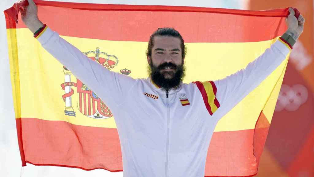 Regino Hernández, feliz, con la bandera de España tras ganar un bronce en los Juegos Olímpicos de invierno.