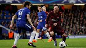 Messi intenta escaparse de los jugadores del Chelsea.