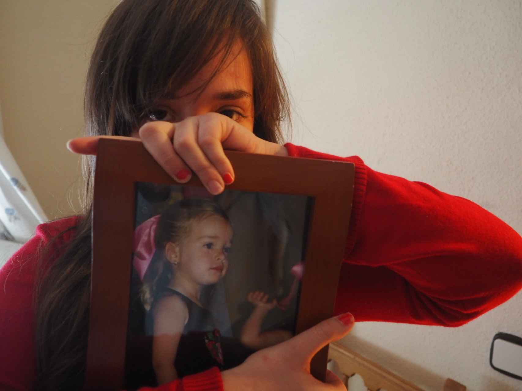 Virginia sostiene una foto de ella durante su infancia. Cuenta que su cuñado abusó de ella a una edad más temprana que la de su hermana Claudia.