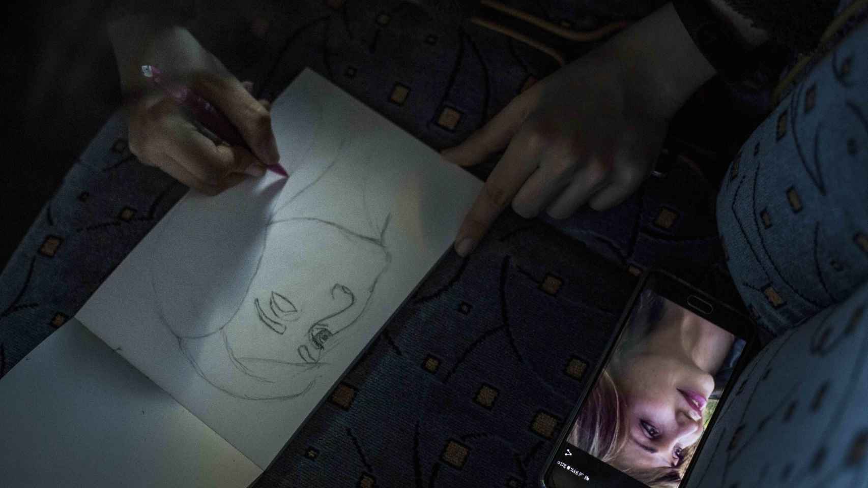 Uno de los viajeros dibuja a la presidenta del colectivo trans, Mar Cambrollé