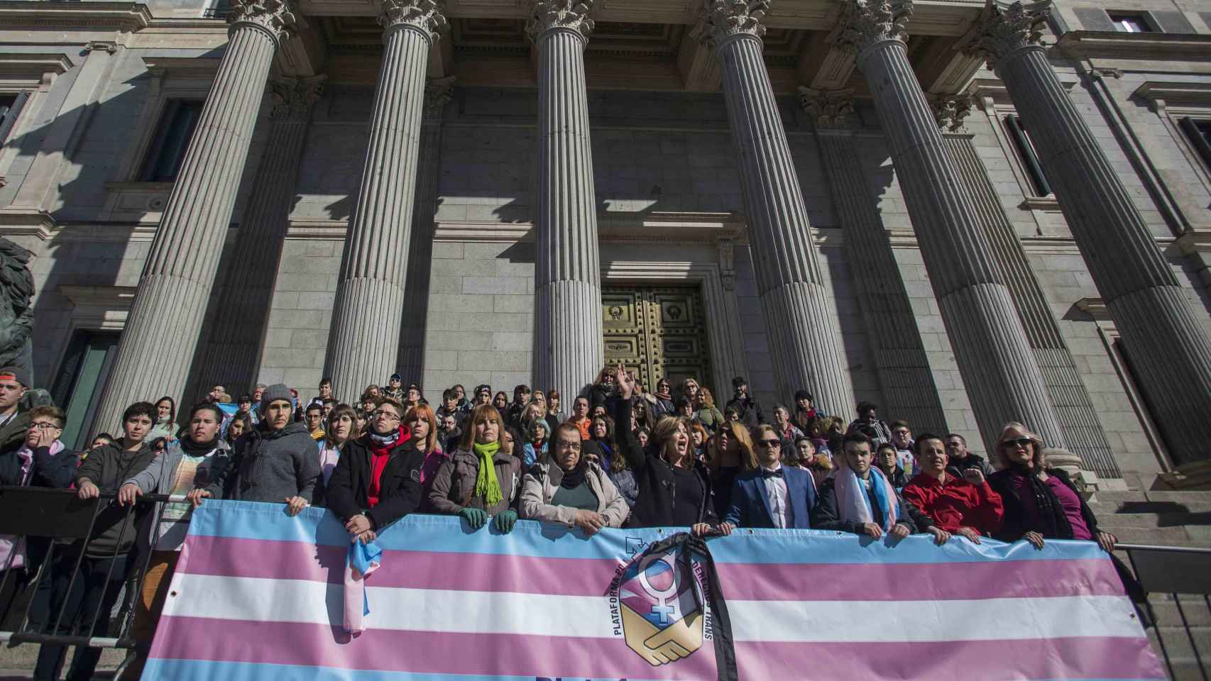 Representantes del colectivo trans junto a políticos de Podemos a las puertas del Congreso de los Diputados