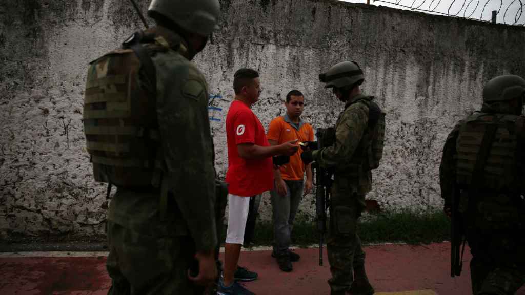 Soldados piden la identificación de dos residentes en en una favela de Rio.
