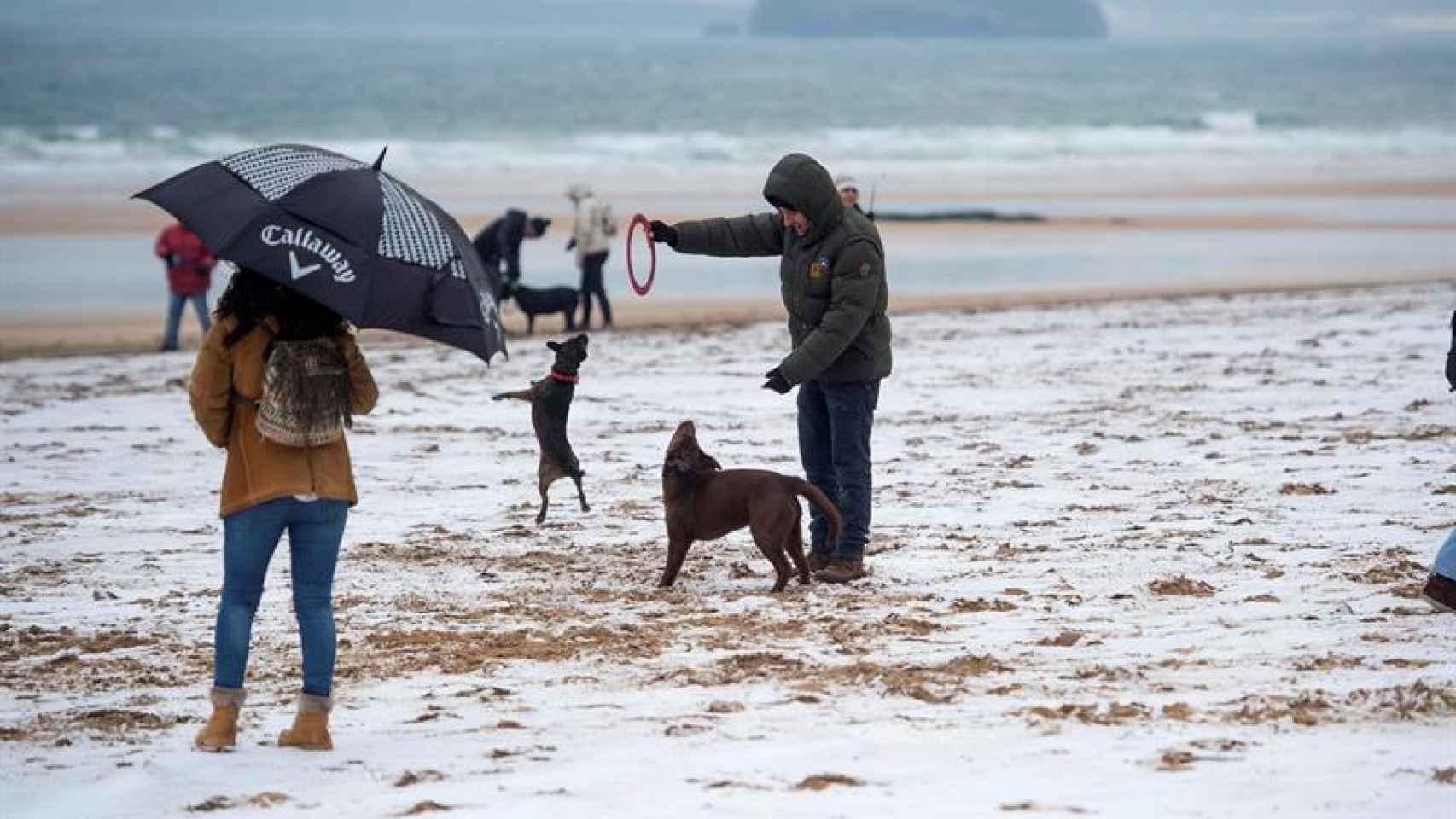 Varias personas disfrutan de la nieve en la playa del Sardinero, en Santander.