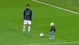 Isco y su hijo sobre el césped del Santiago Bernabéu
