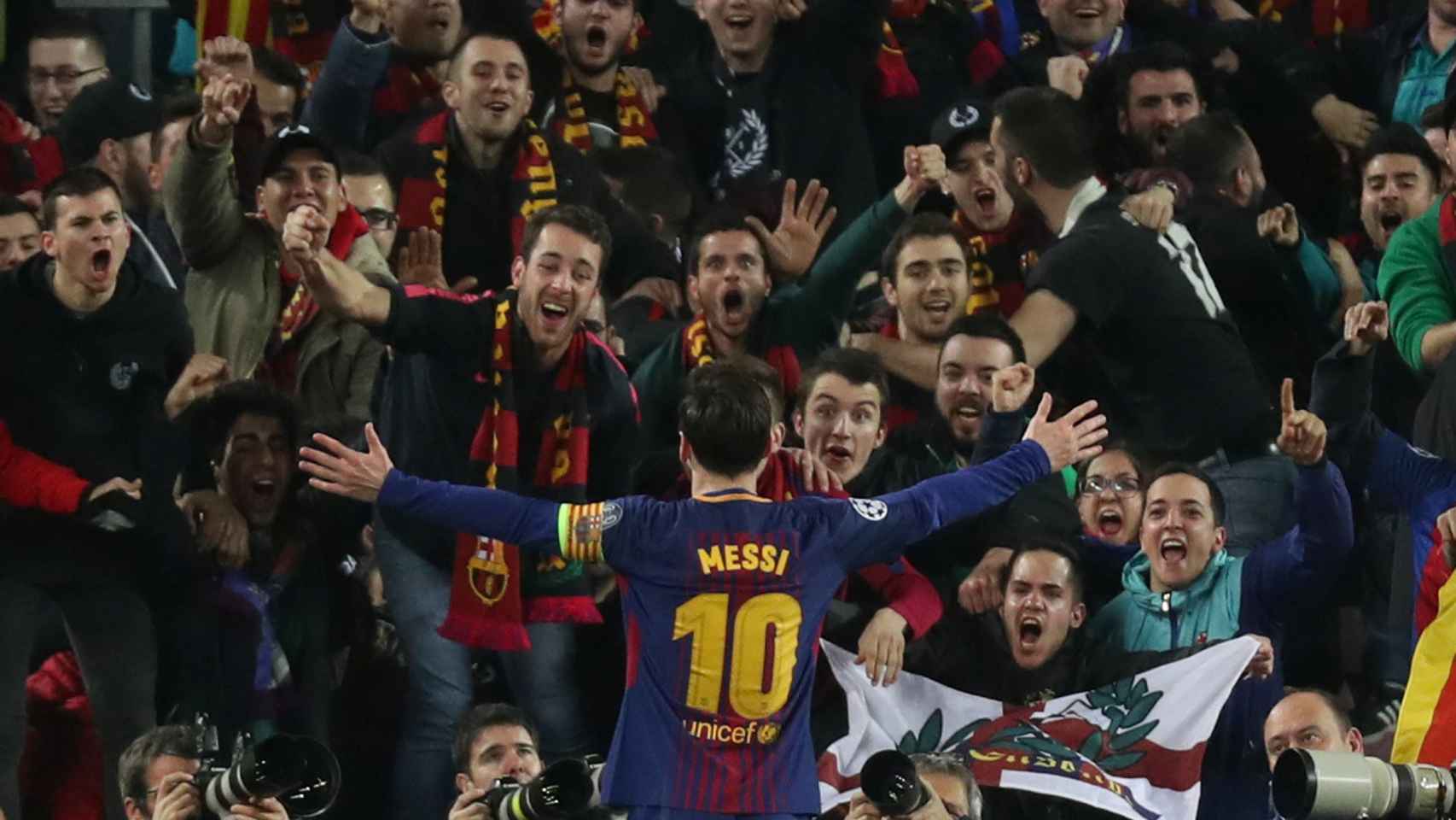 Messi celebra su gol con aficionados del Barcelona.