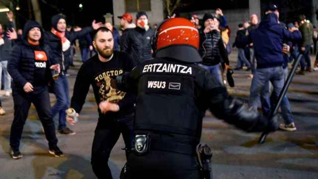 Un ertzaina trata de parar a uno de los ultras antes del partido entre Athletic y Spartak.