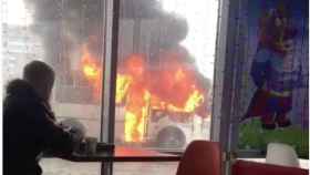 Un ruso disfruta de un café a unos metros de un autobús ardiendo