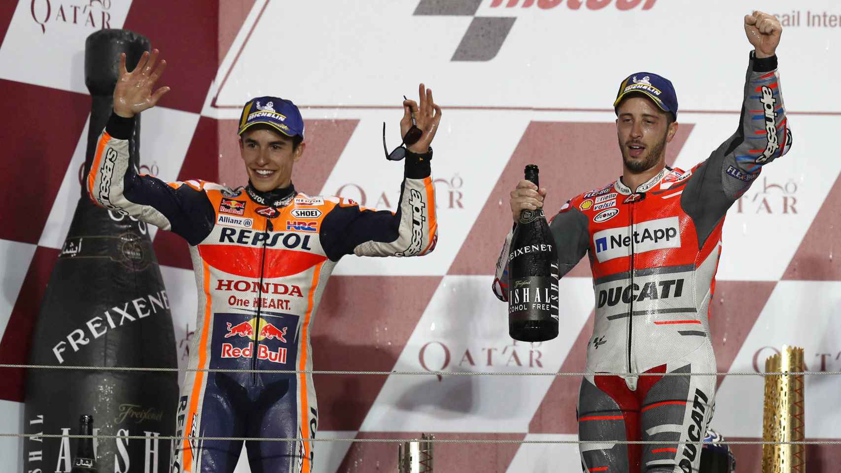 Dovizioso, en lo más alto del podio, celebra su victoria en el GP de Qatar junto a Márquez.