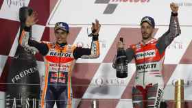Dovizioso, en lo más alto del podio, celebra su victoria en el GP de Qatar junto a Márquez.