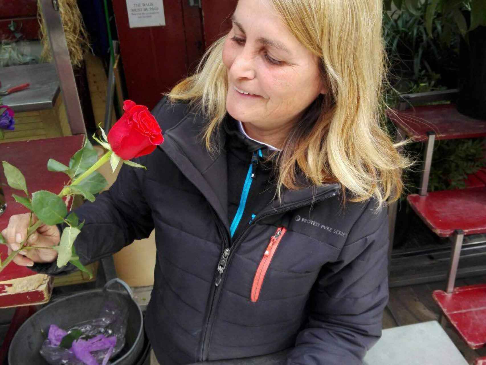 Una florista de La Rambla mostrando la tradicional rosa roja
