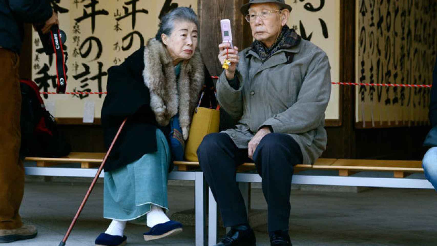 Una pareja japonesa consulta su teléfono móvil.