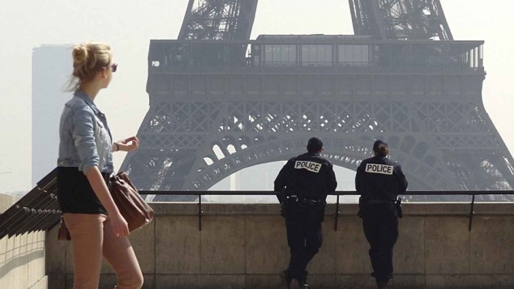 Una turista junto a dos policías en la Torre Eiffel