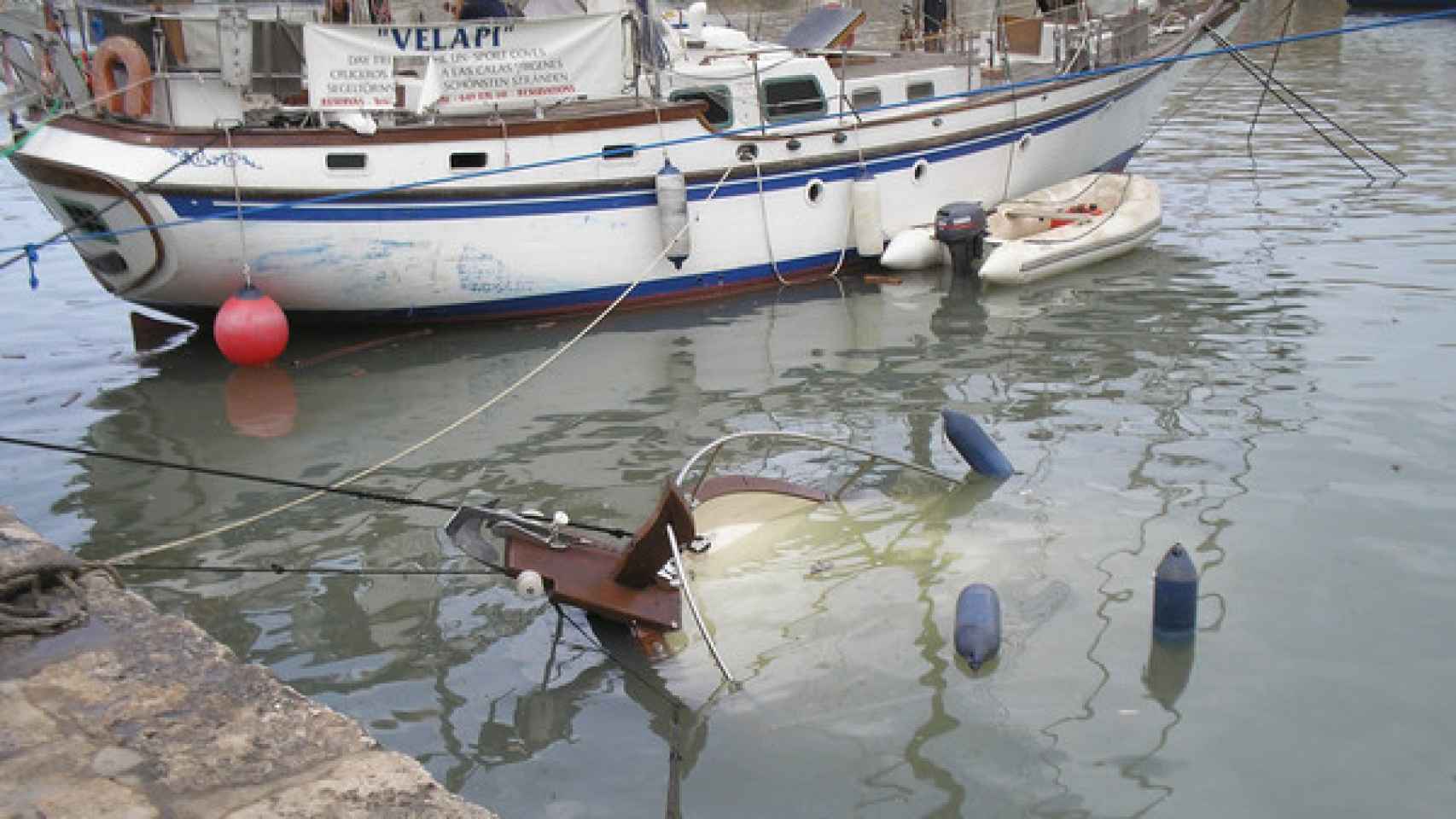 Embarcación hundida por una rissaga que sufrió el puerto de Ciutadella.