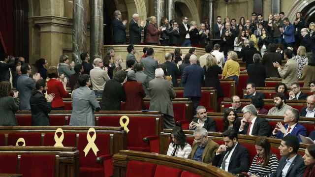Imagen de un pleno, con diputados independentistas de espaldas, aplaudiendo a víctimas de políticos presos.
