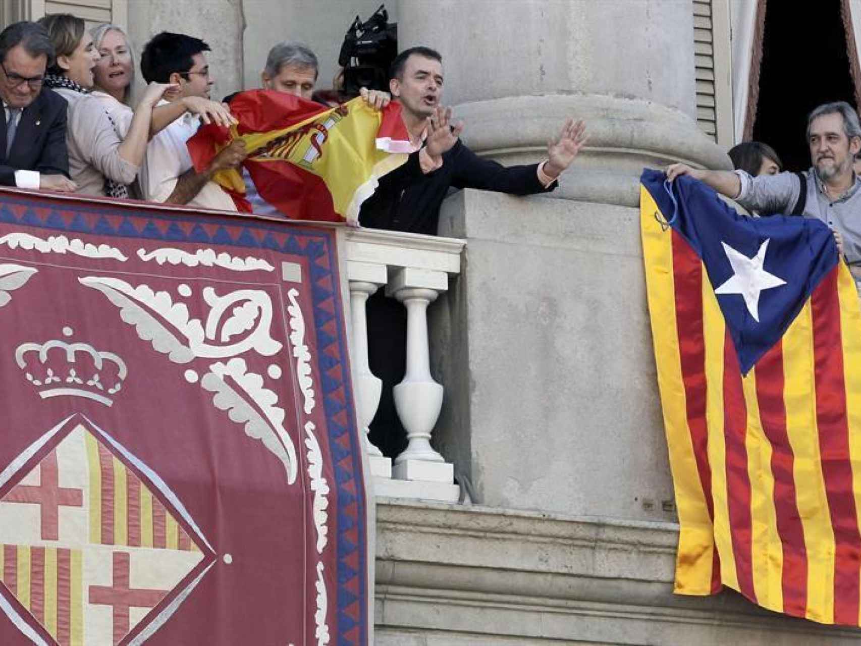 Gerardo Pisarello intenta arrancarle una bandera española de las manos a Alberto Fernández, del PP.