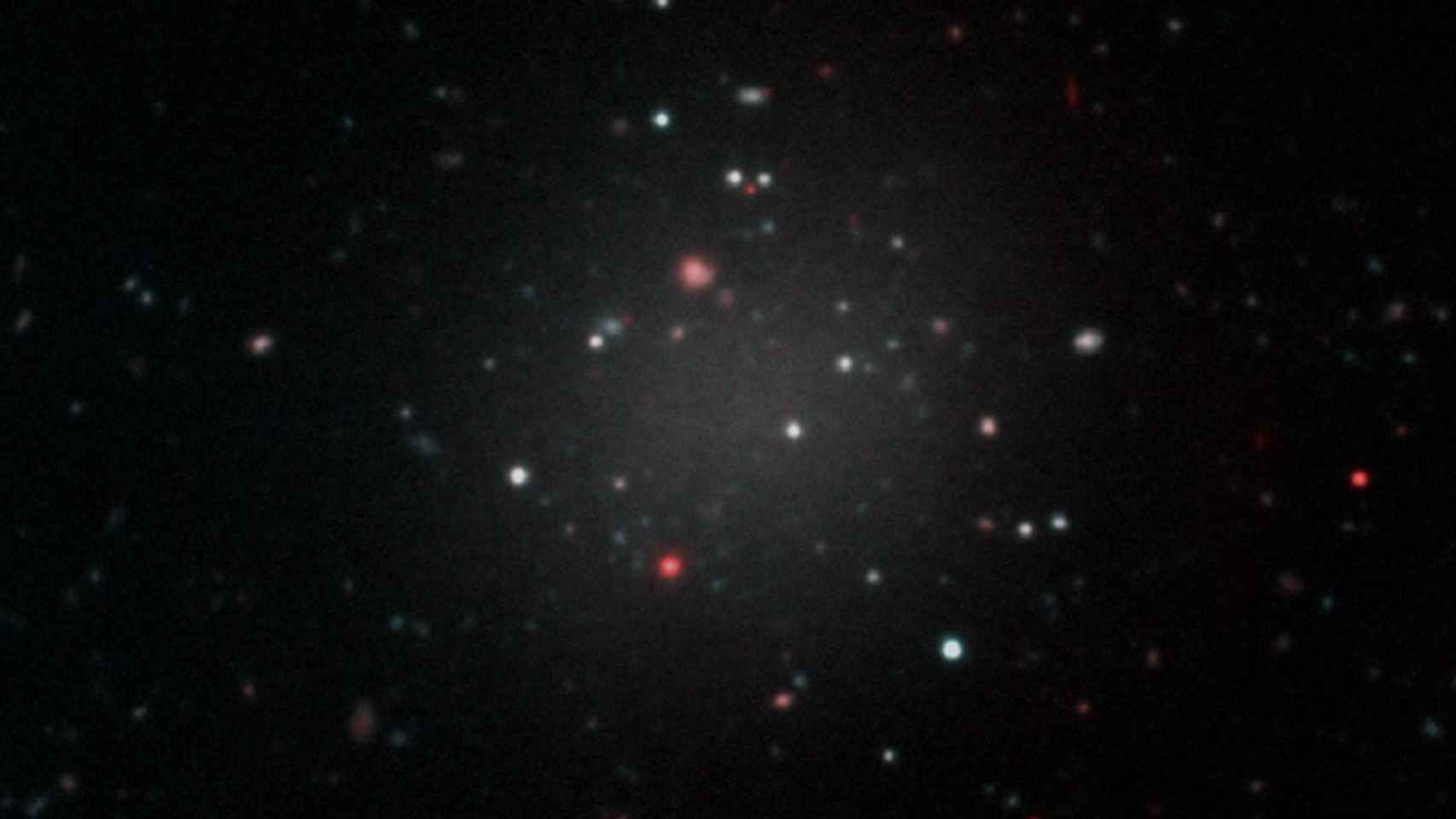Entorno de la galaxia NGC1052 (esferoide blanquecino a la izquierda), en cuyas proximidades se encuentra NGC1052-DF2.