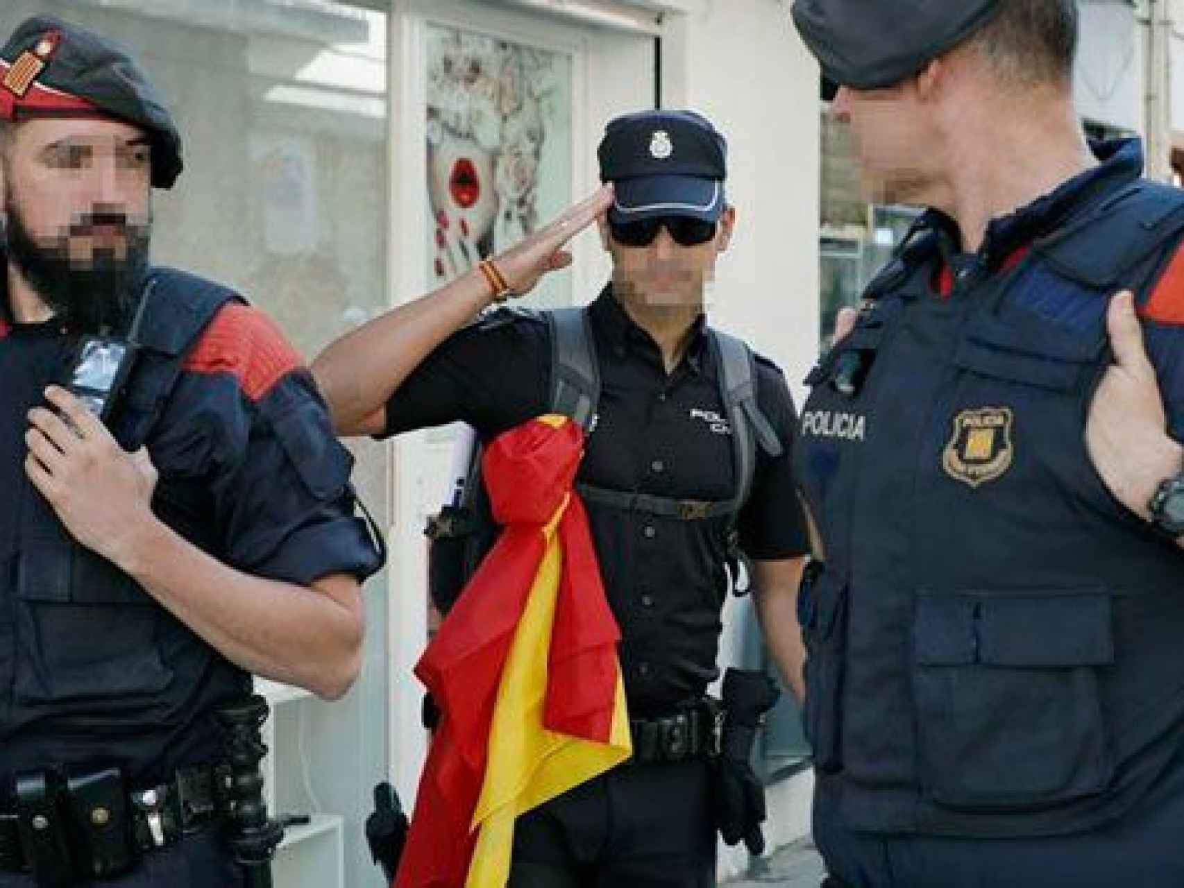 Un policía nacional se despide de los ciudadanos que le aplauden después de ser desalojado de su hotel en la costa catalana.