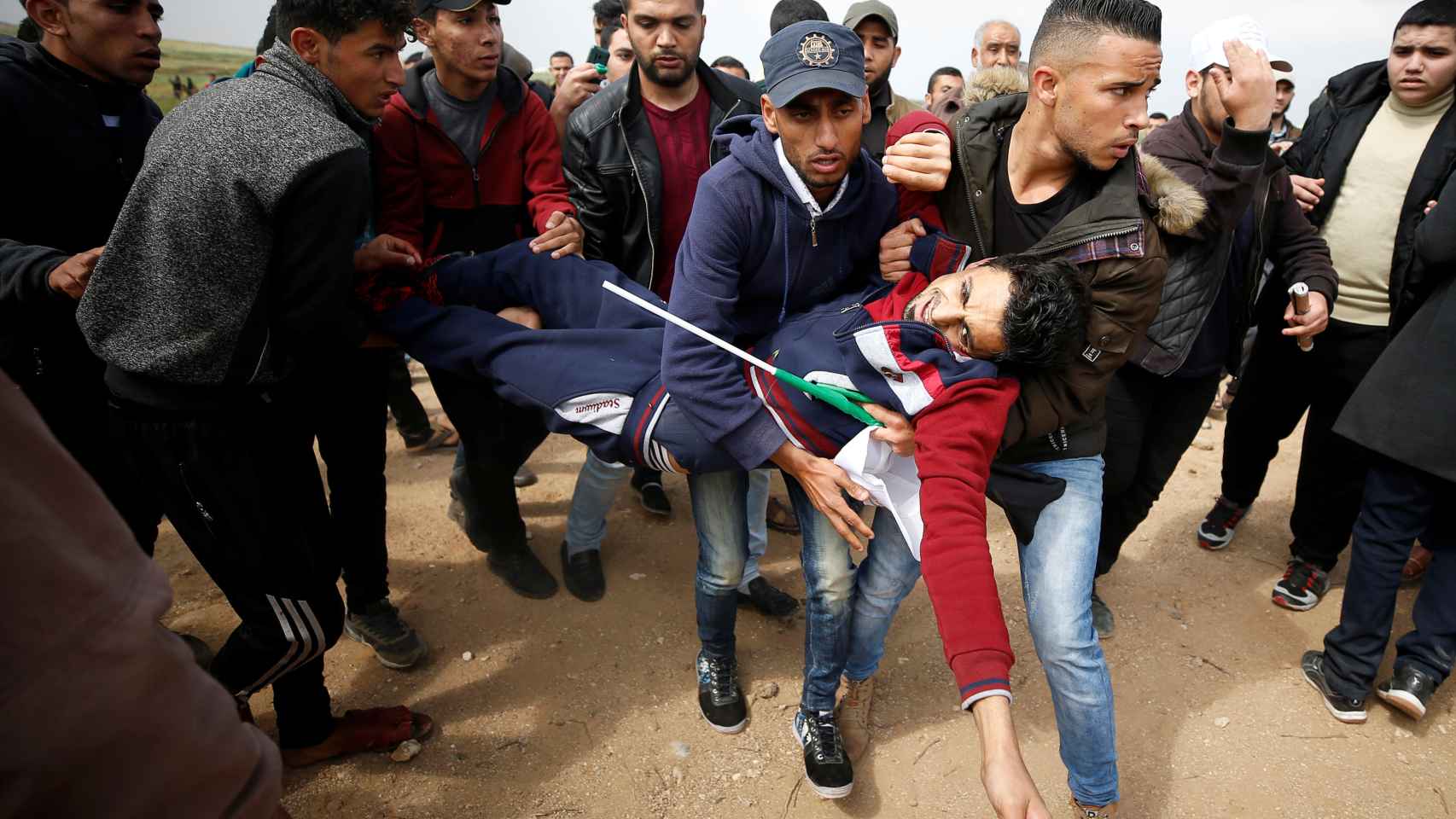 Varios palestinos transportan a un herido por el choque con el ejército israelí.