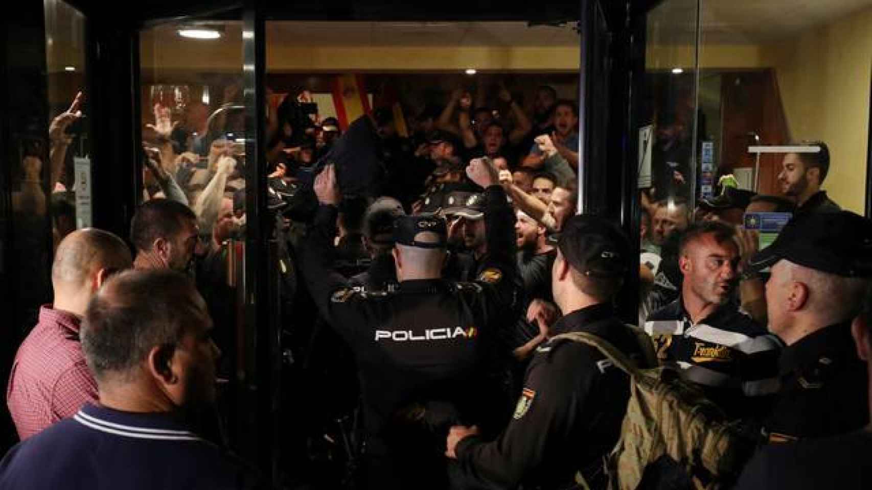 Agentes de la Policía Nacional rodeados por manifestantes en Pineda de Mar./