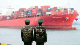 Dos guardias fronterizos mientras hacen guardia en un puerto en Qingdao (China).