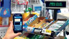 Un cliente con un móvil en un supermercado, en una imagen de archivo.