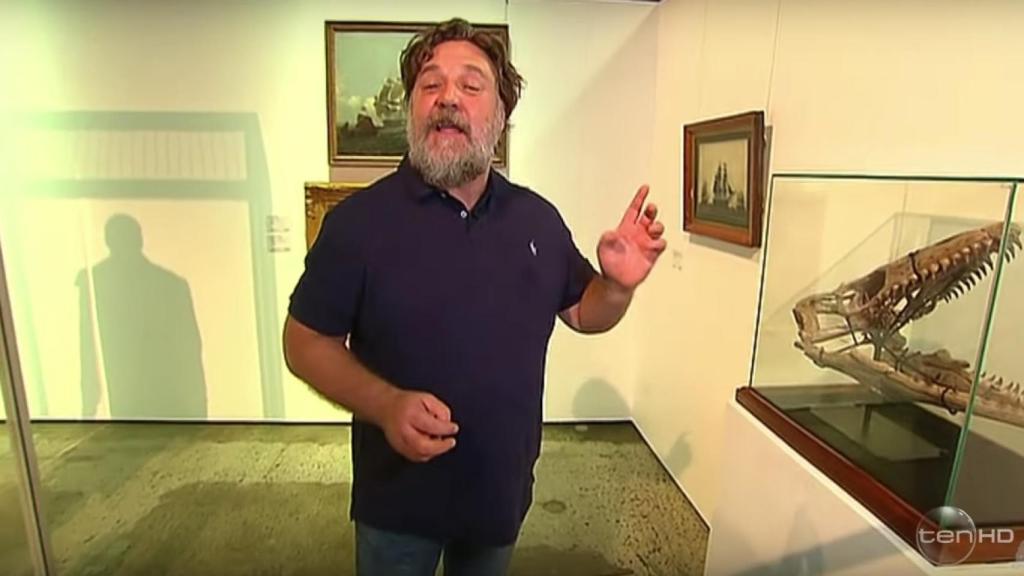 Russell Crowe junto al cráneo de dinosaurio que sacó a subasta.