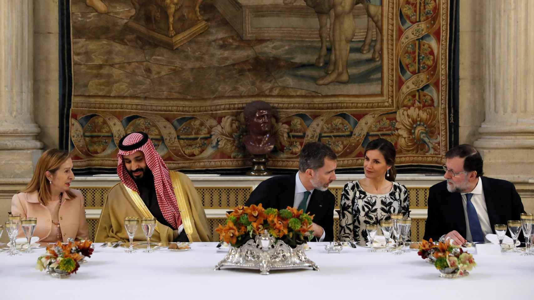 Sentados en la mesa, los reyes conversan con Mariano Rajoy.