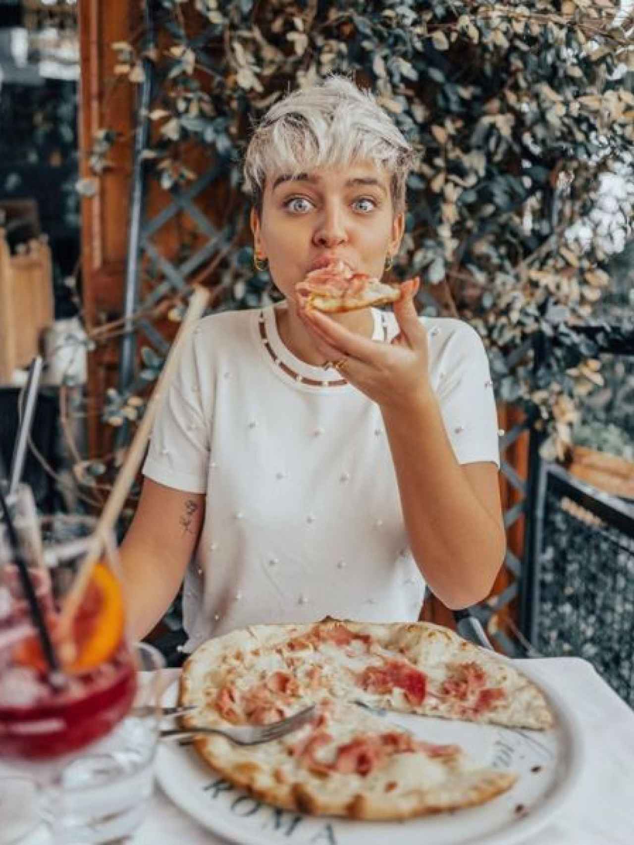 Laura Escanes está feliz por la pizza que está degustando.