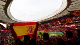 Un aficionado alza una bandera de España en la zona de aficionados del Barça en el Metropolitano.