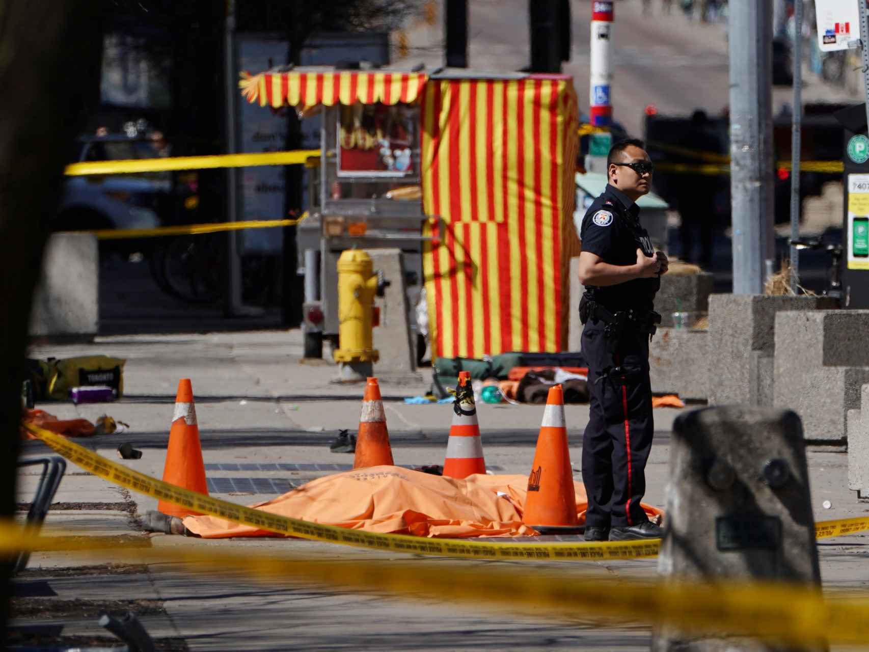 Un policía junto a una de las víctimas mortales del atropello de Toronto.