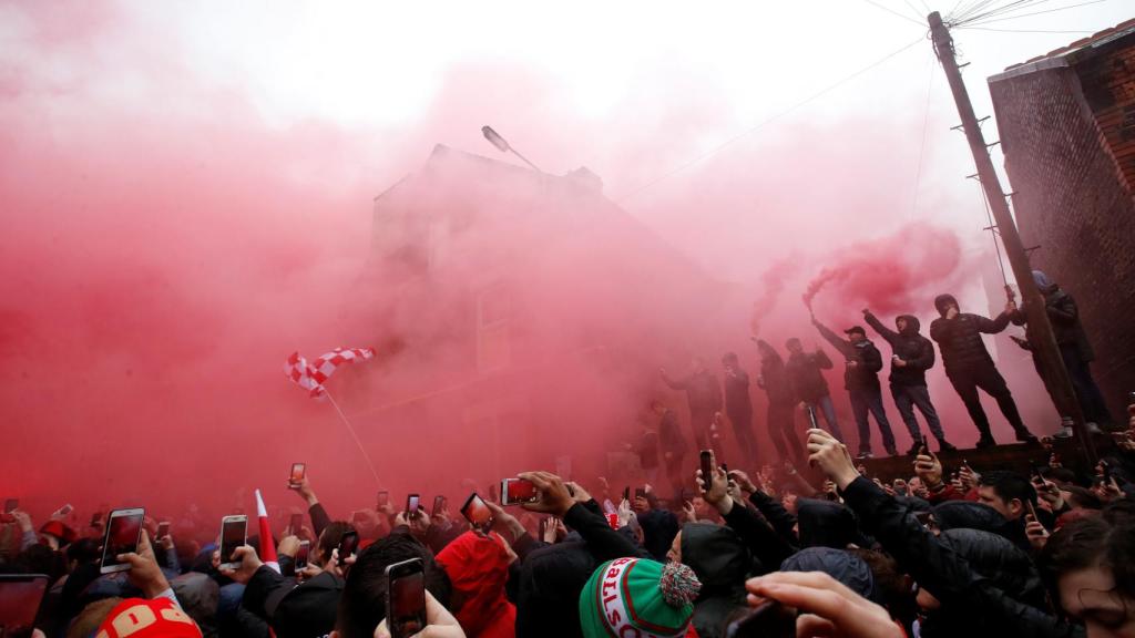 Los seguidores del Liverpool encienden bengalas antes del partido.