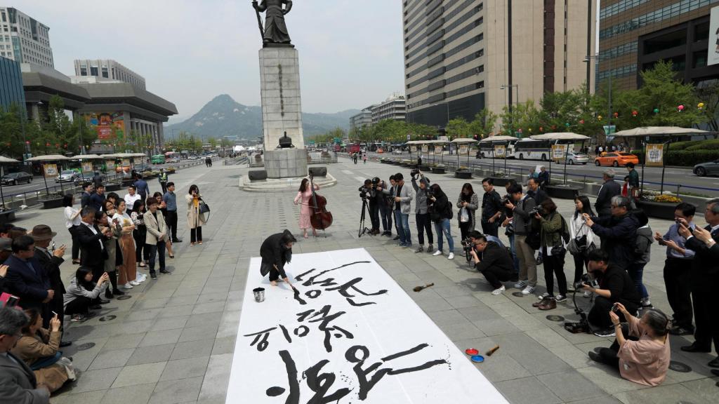 Un artista surcoreano realiza un pintura durante un acto a favor de la unificación entre las dos Coreas.
