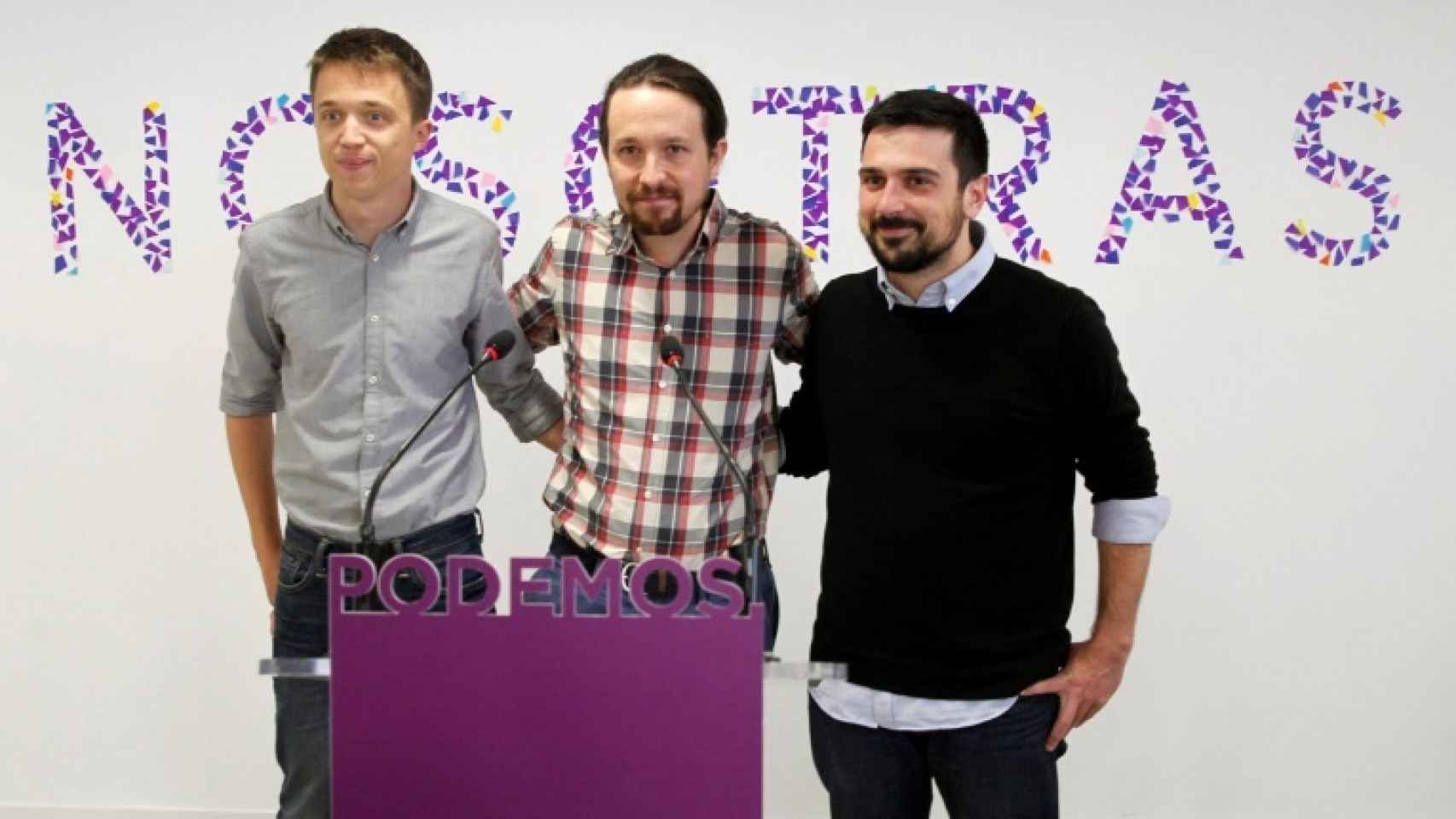 Íñigo Errejón, Pablo Iglesias y Ramón Espinar con el polémico lema a sus espaldas.