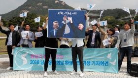 Un grupo de estudiantes sostiene dos carteles de Kim Jong-un y Moon Jae-in.
