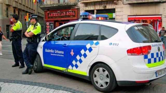 Dos agentes de la Guardia Urbana vigilando una calle de la ciudad de Barcelona.