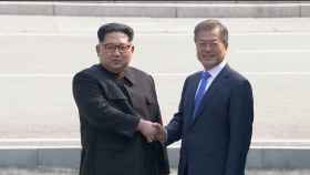 Kim Jong-un (i),estrecha la mano del presidente de Corea del Sur,  Moon Jae-in (d).
