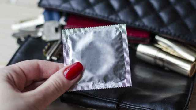 Una mujer sujeta un preservativo.
