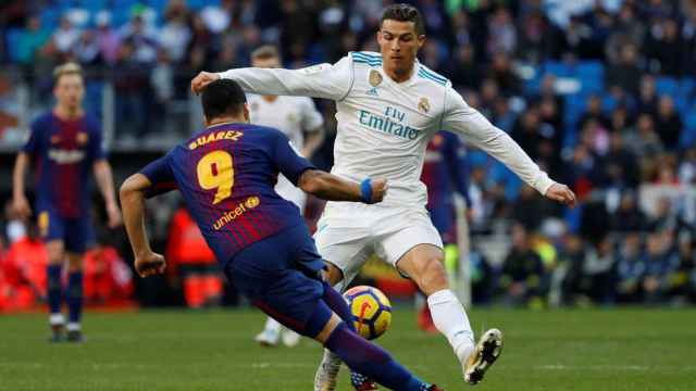 Cristiano Ronaldo y Luis Suárez disputan un balón en el Madrid - Barcelona.