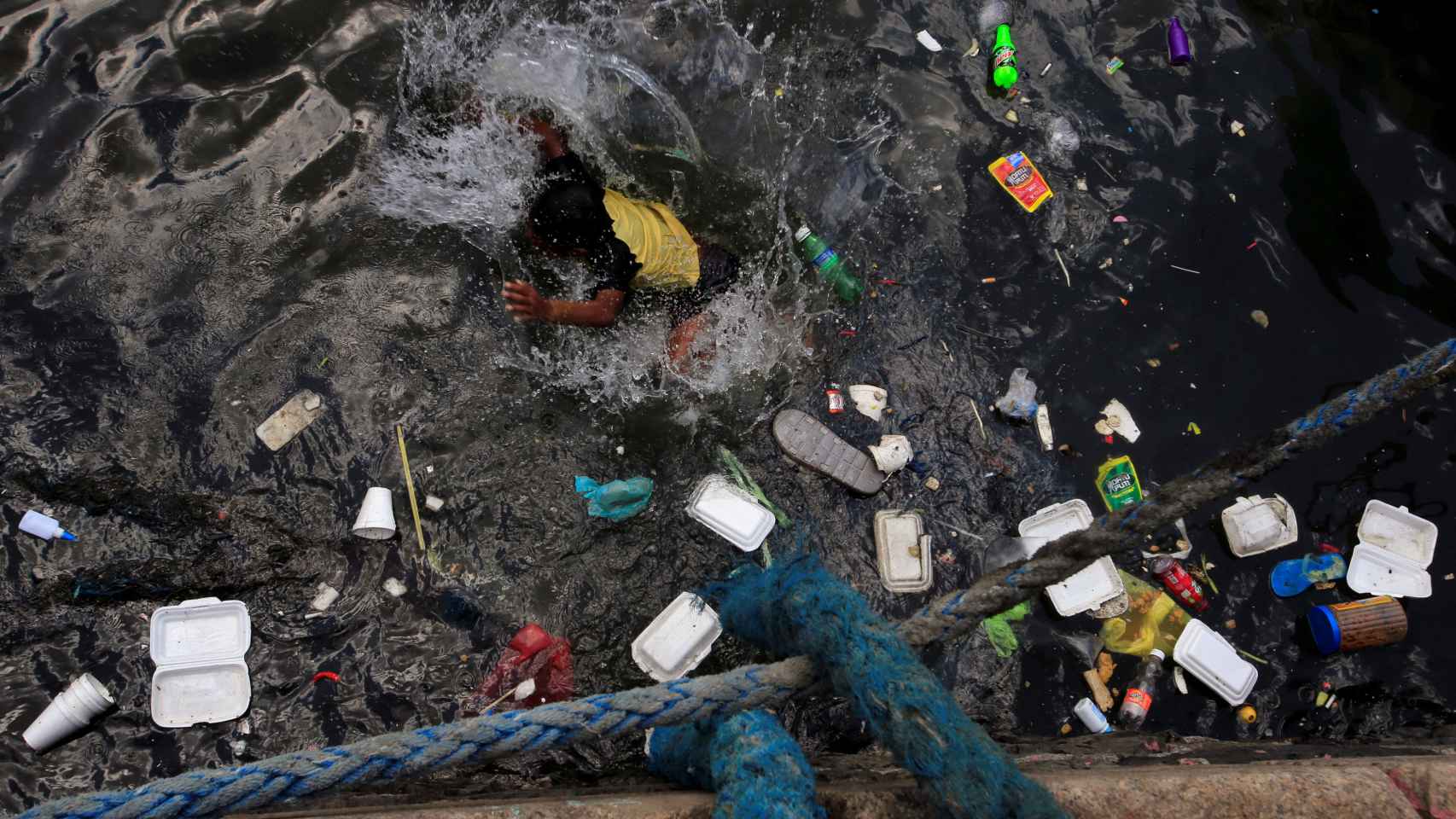 Envases de plástico desperdiciados en el agua en la que nadan los niños del suburbio de Baseco, en Manila, Filipinas.