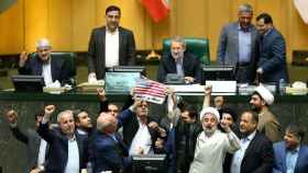 Un grupo de diputados iraníes queman una bandera de EE.UU.