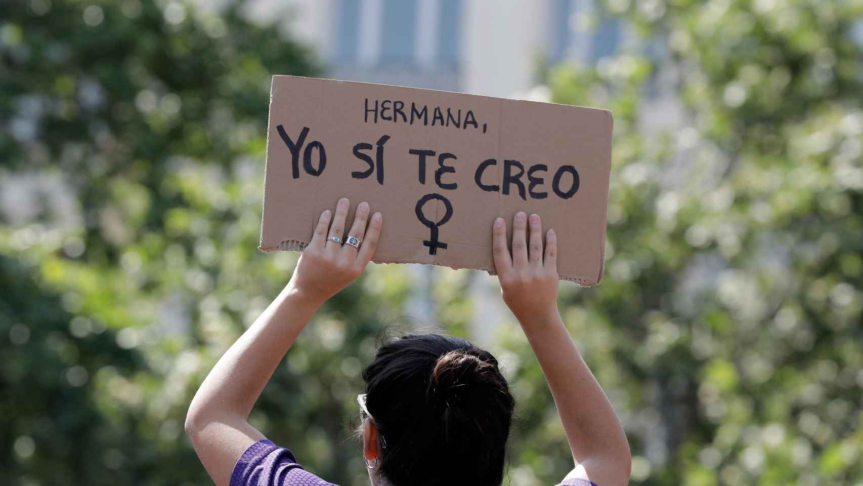 Un chica levanta un cartel de apoyo a la víctima de 'La Manada'