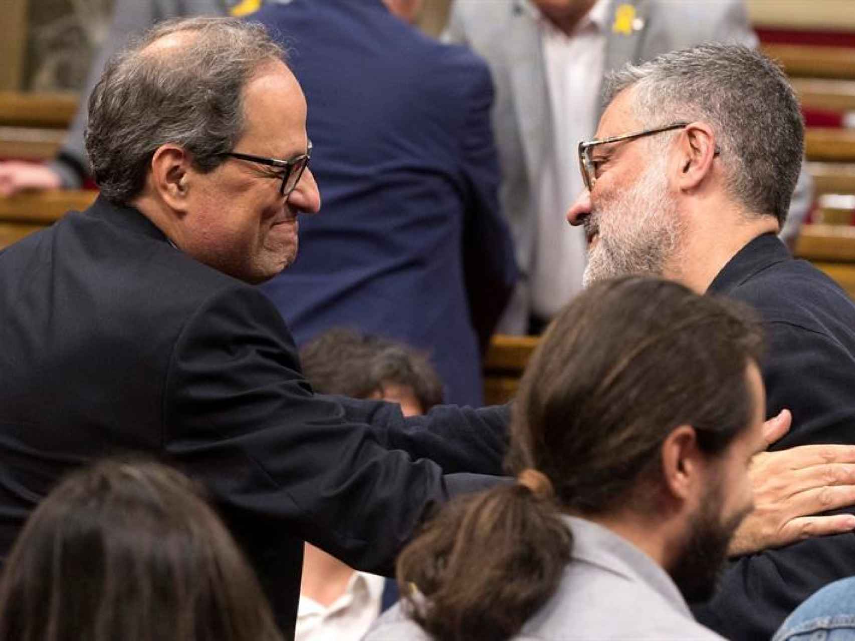 Quim Torra saluda al diputado de la CUP Carles Riera en el Parlamento de Cataluña el pasado sábado.