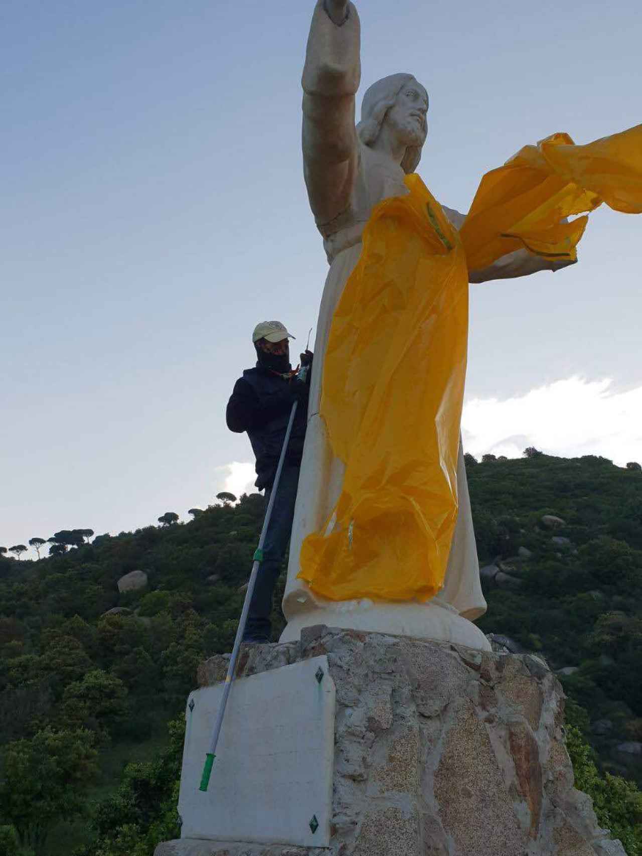 Un miembro de Segadors retira los plásticos amarillos del Cristo de Teià