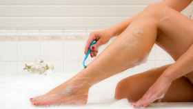 Una mujer se afeita las piernas con una cuchilla.