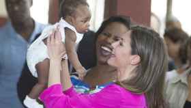 La reina Letizia coge en brazos a un bebé haitiano.