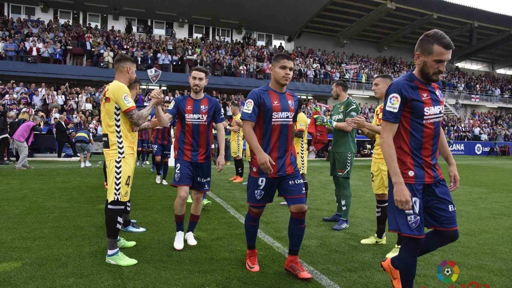Los jugadores del Huesca le hacen el pasillo a los del Nastic.