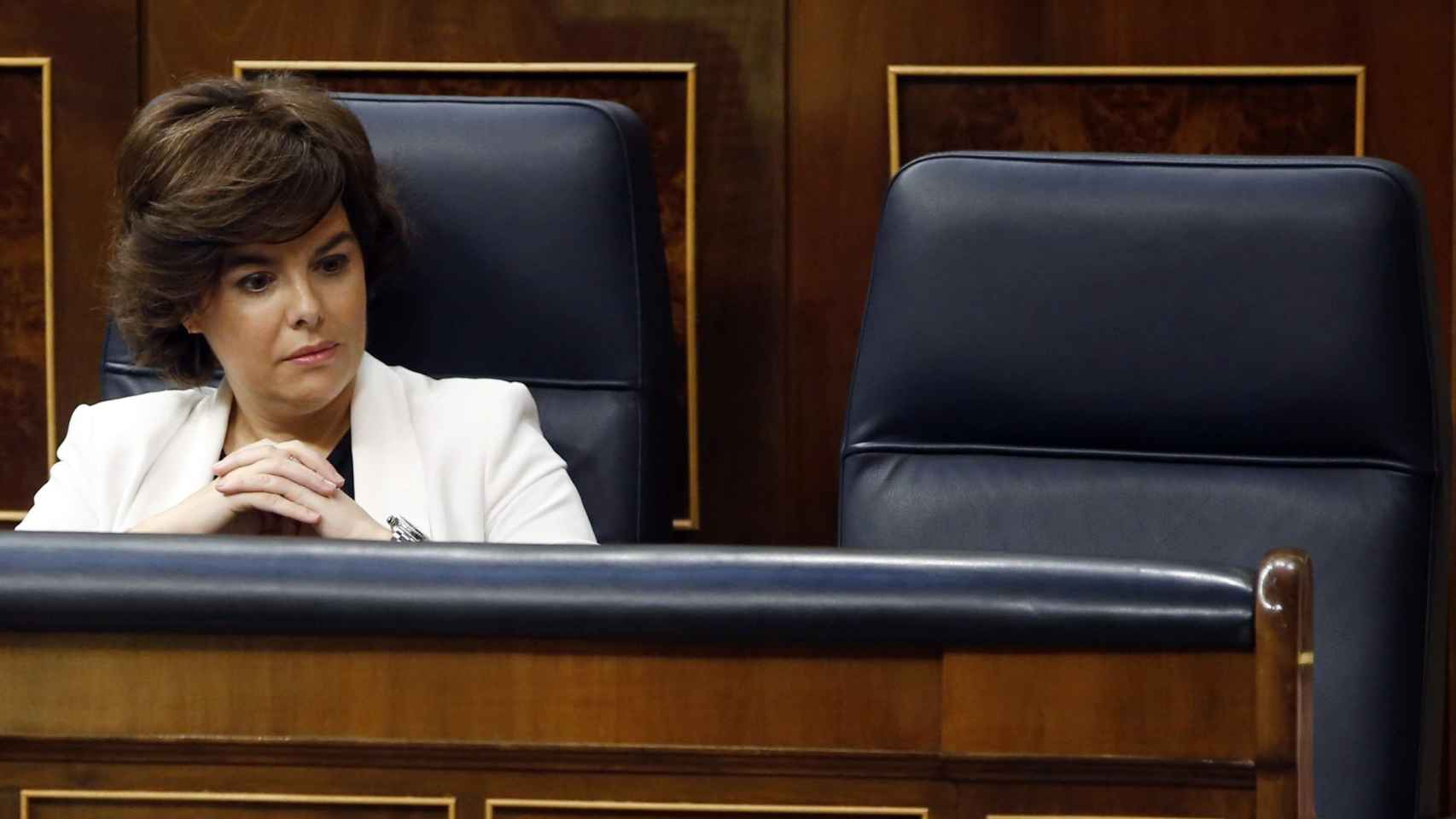 La vicepresidenta del Gobierno, Soraya Sáez de Santamaría, con el asiento vacío de Rajoy.