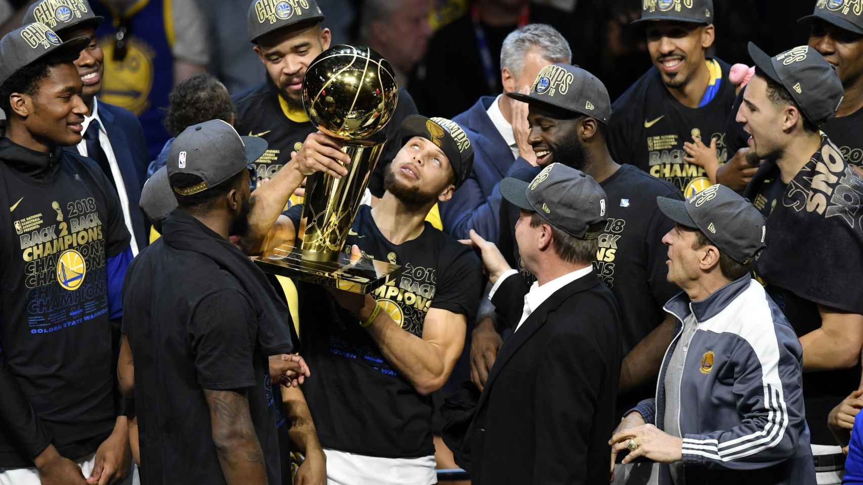 Curry alza el trofeo de campeones de la NBA rodeado por su equipo