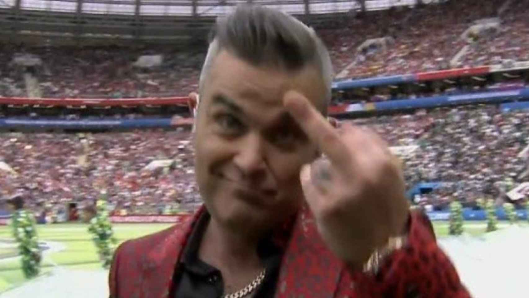Robbie Williams hace una peineta a la cámara, durante la ceremonia inaugural.